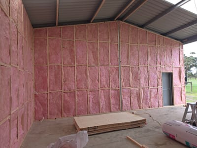 Insulation batts fitted into timber wall studs before plasterboard install